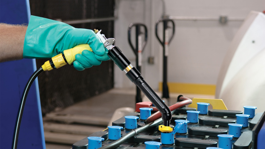 A man using a Philadelphia Scientific Battery Watering Gun to water a lead acid battery