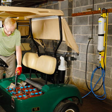 Man using the hydropure on a golf buggy battery