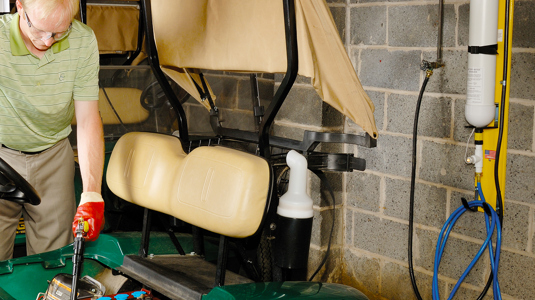 Man using the hydropure on a golf buggy battery