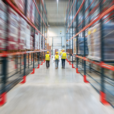 People walking through a busy warehouse.